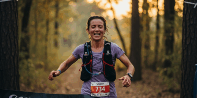 trail runner finishing ultramarathon race exhausted and triumphant crossing finish